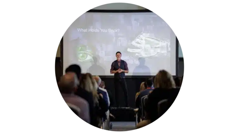 Mike Rayburn delivering a high-impact keynote to a corporate audience, sharing tools and mindset for world-class performance and innovation